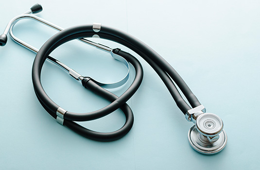coiled-stethoscope-on-a-blue-background-H65E3JY