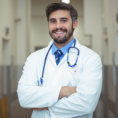portrait-of-male-doctor-standing-in-corridor-U7CHFXB